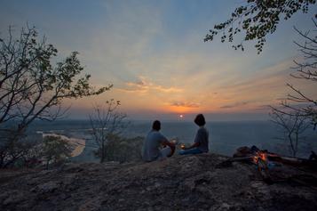 Couple watching the sunset on a hill in Gorongosa of Mozambique