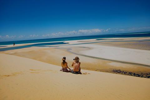 A couple looking over the Bazaruto in Mozambique from the dunes