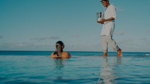 Woman having drinks served to her in the pool